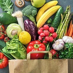 Paper grocery bag with mixed vegetables.